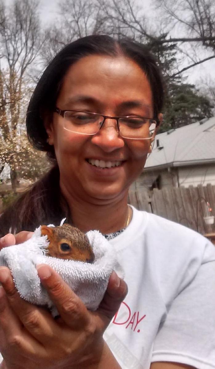 Madhumita Gupta holding a rescued squirrel wrapped in a towel