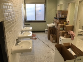 Renovated first floor bathroom with new tile, floors, and enclosed stalls