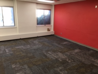 Renovated classroom with new carpet and red accent wall