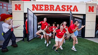 New Student Enrollment leaders blast onto the field as part of the Tunnel Walk into Memorial Stadium for incoming students.