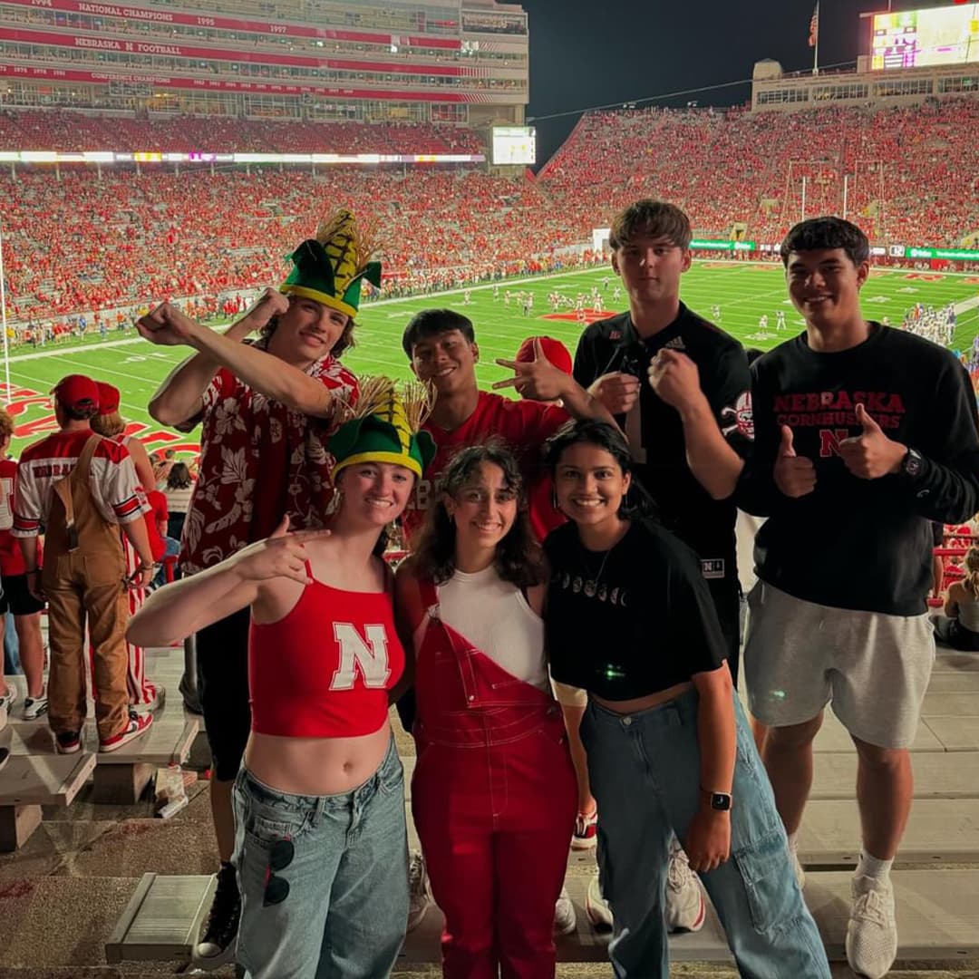 A group of Huskers pose in the bleachers at Memorial Stadium during the football game.