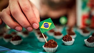 A tiny Brazil flag is inserted into a piece of Brigadeiro.