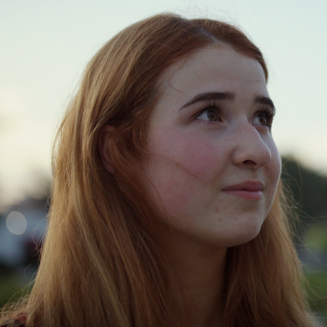 Student at dusk looking up at sky