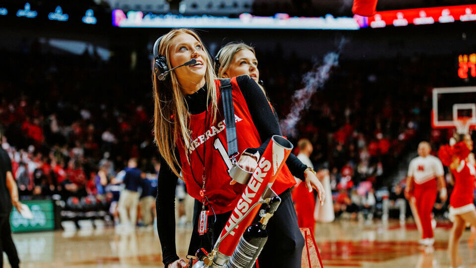 Student standing on basketball court wearing headset