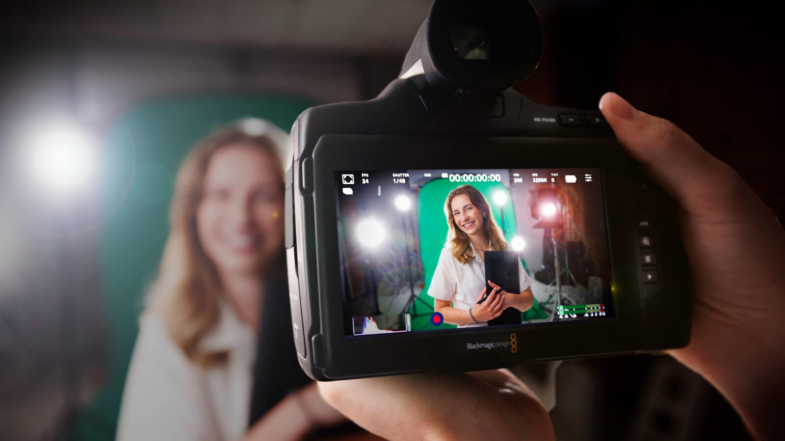 Student in front of green screen as seen through viewfinder of camera