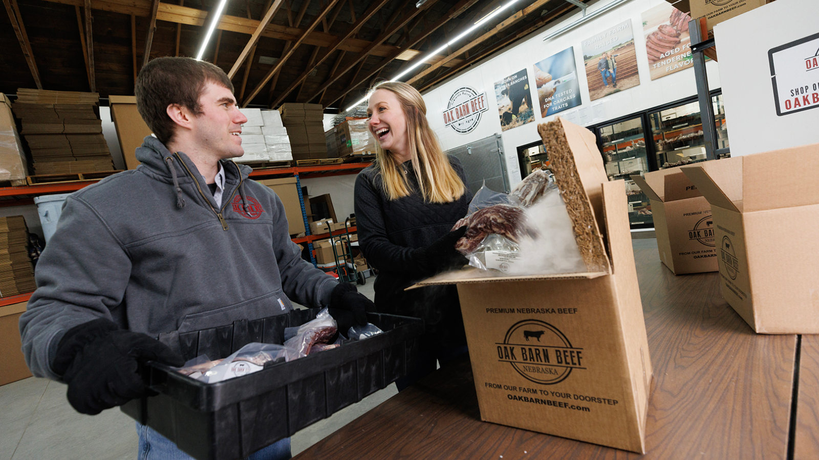 Students who graduated from the Engler program lift boxes being shipped from their new business