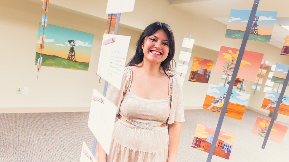 Student standing in gallery with letters and other papers hanging down