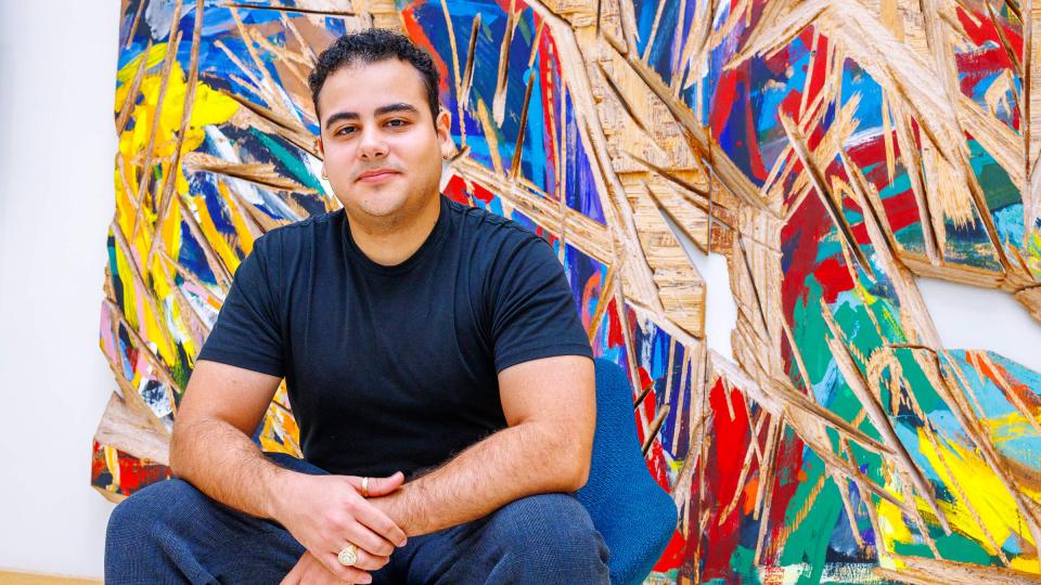 Student sitting in front of abstract mural