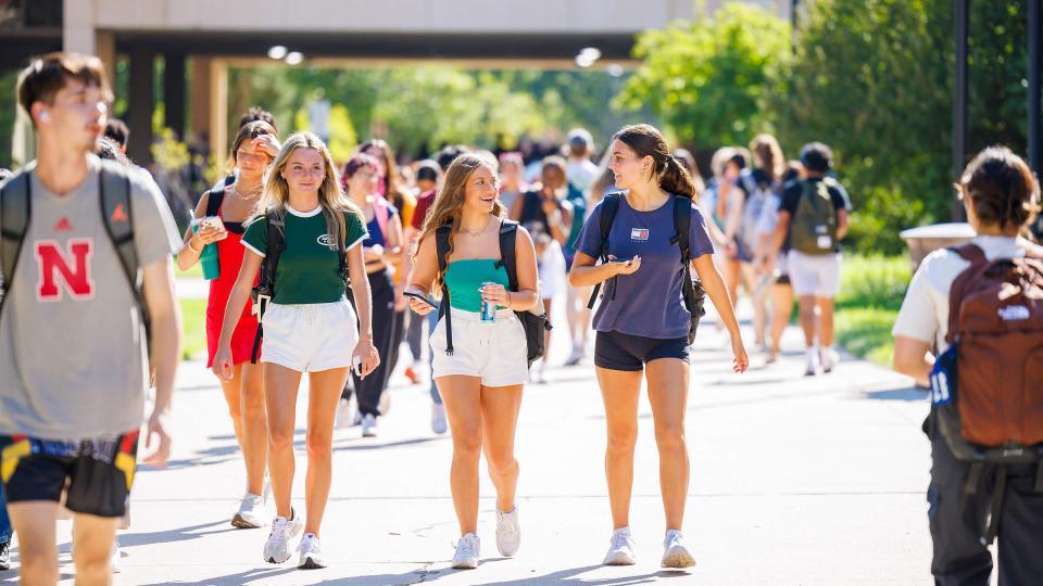 Students walking in group by Love Library on first day of semester